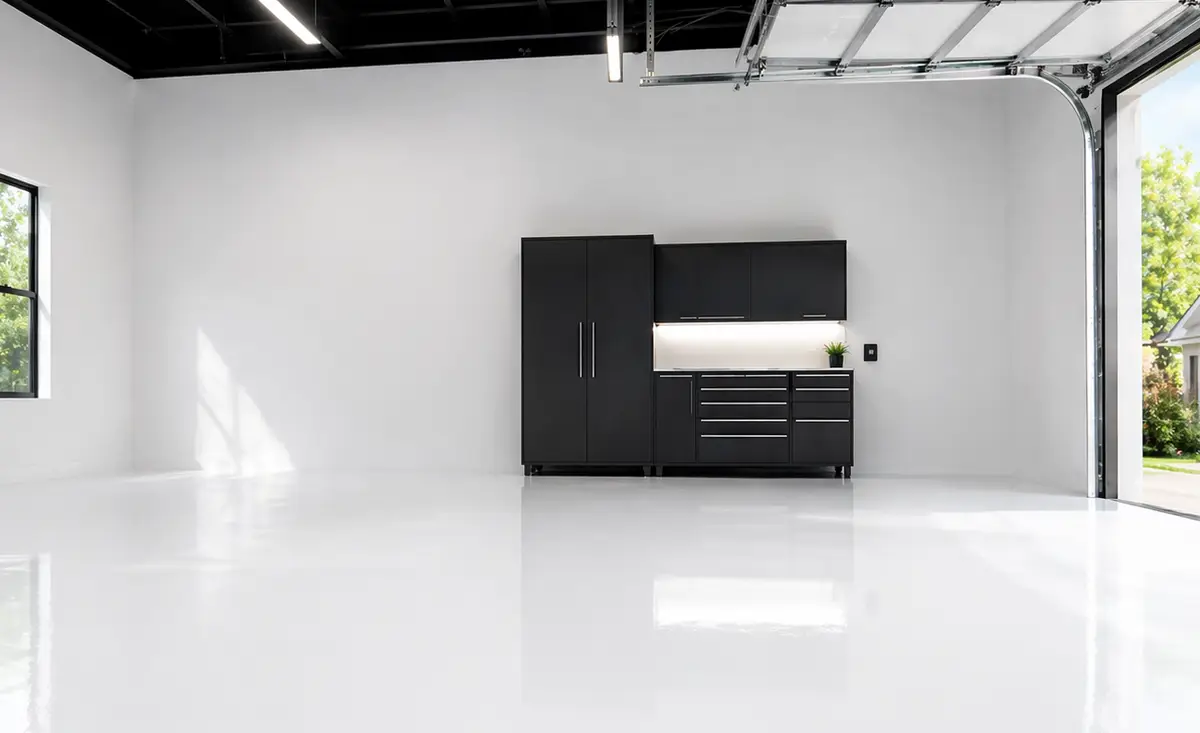 Spacious white garage with glossy floor and black cabinets against the back wall