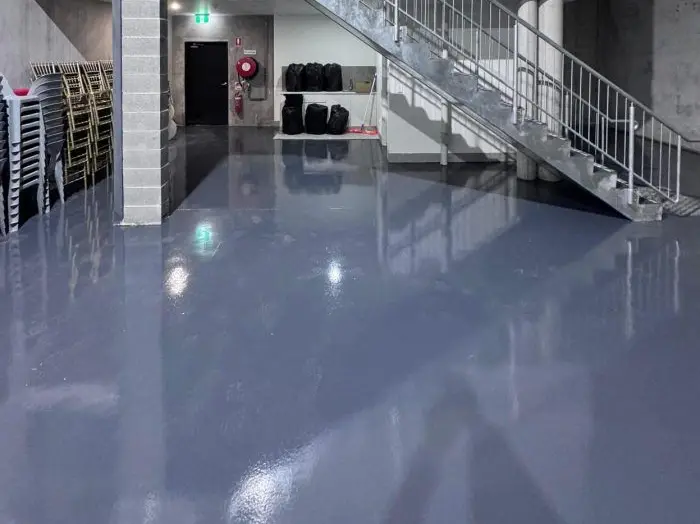 Commercial space with a gray epoxy floor and stairs to a mezzanine