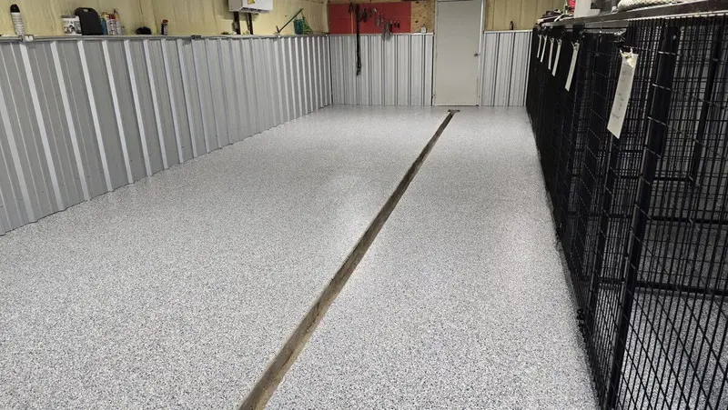 Commercial kennel aisle with a seamless light gray flake floor